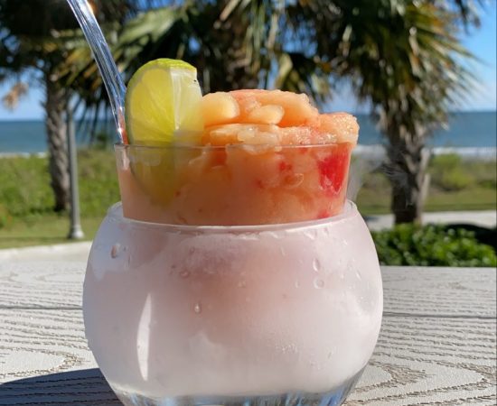 A cocktail on the table with trees in the background