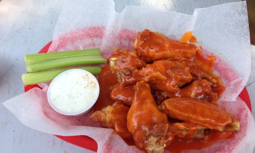 Buffalo chicken wings in a bowl with celery and blue cheese