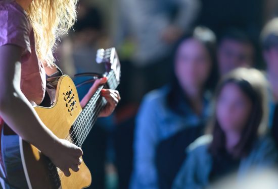 Female musician playing the guitar at a concert