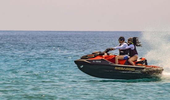 couple jetskiing on the ocean couple jetskiing on the ocean