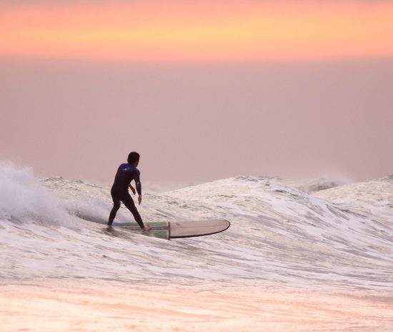 Guy Surfing at Sunrise