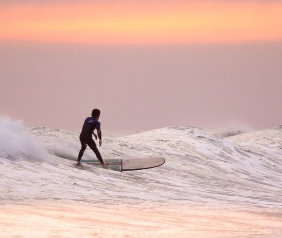Guy Surfing at Sunrise Guy Surfing at Sunrise